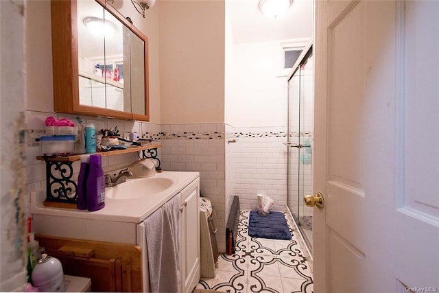 bathroom with tile patterned floors, an enclosed shower, vanity, tile walls, and toilet