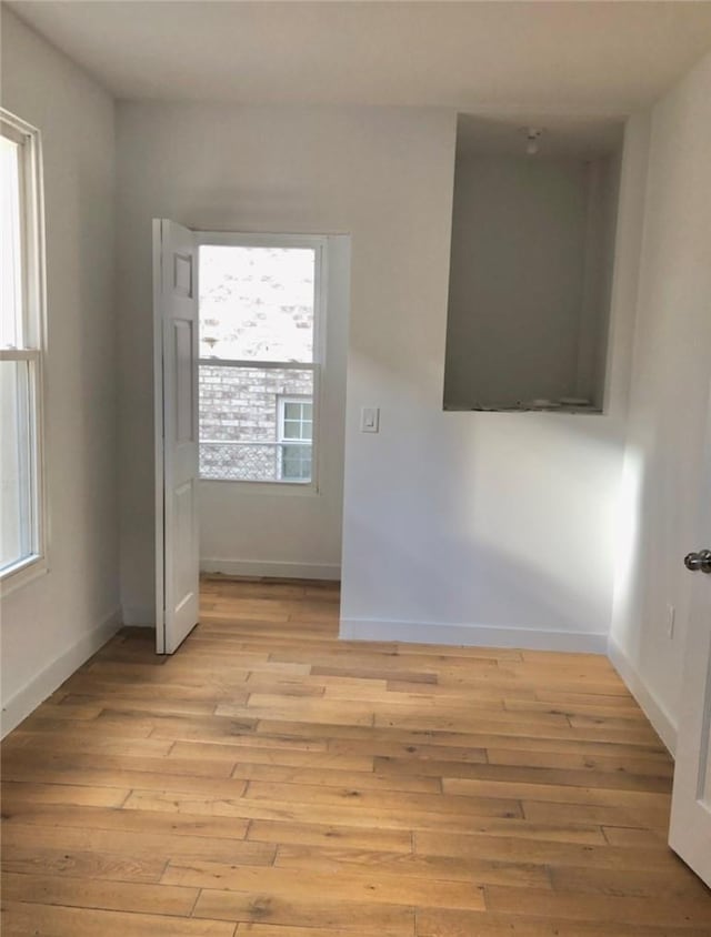 spare room featuring a wealth of natural light and light wood-type flooring