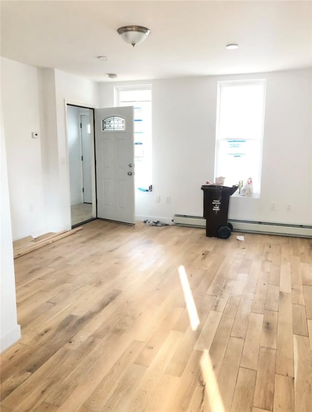 foyer entrance featuring light wood-type flooring and a baseboard radiator