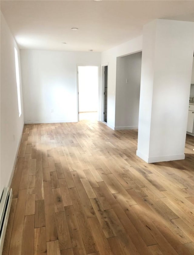 unfurnished room with light hardwood / wood-style flooring and a baseboard radiator