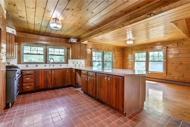 kitchen with kitchen peninsula, backsplash, wood ceiling, a baseboard heating unit, and wooden walls