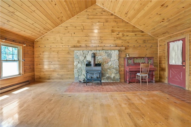 unfurnished living room with wood-type flooring, a wood stove, wooden ceiling, and wood walls