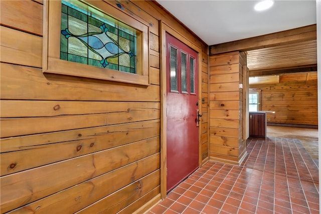 hallway with dark tile patterned floors and wooden walls