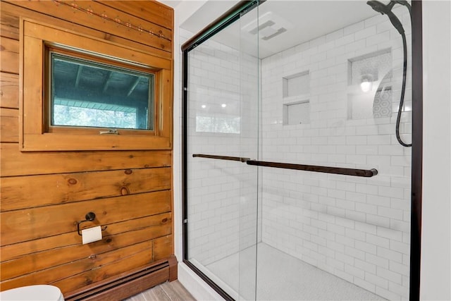 bathroom featuring wood walls and a shower with door