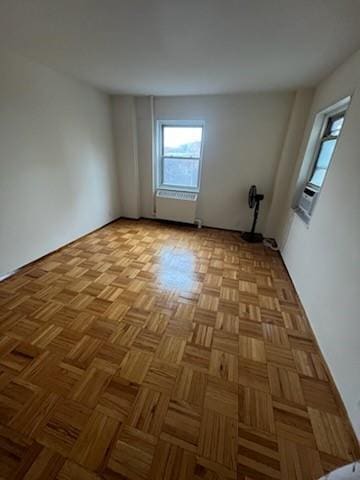 spare room featuring cooling unit and light parquet flooring