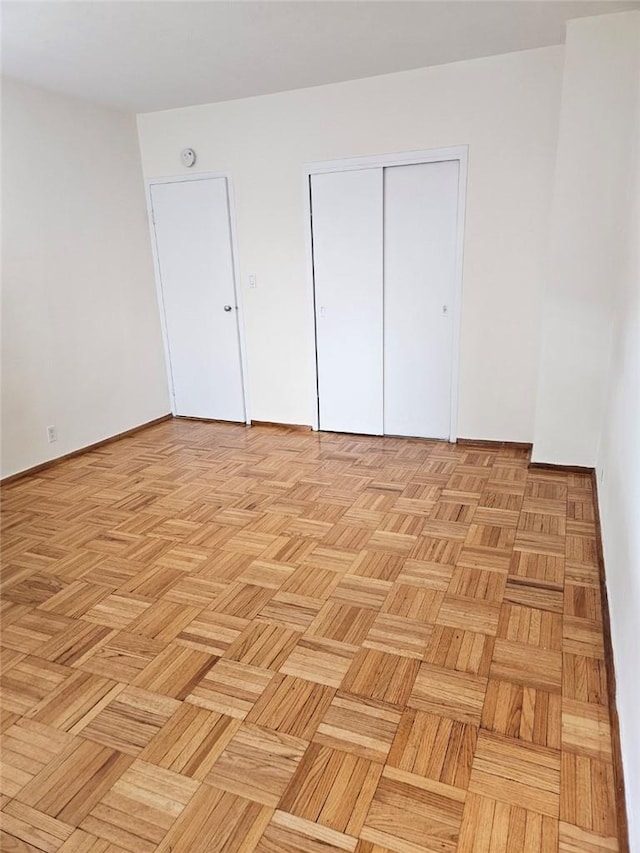 unfurnished bedroom with a closet and light parquet floors