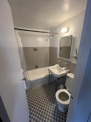 full bathroom featuring shower / bath combination with curtain, toilet, and sink