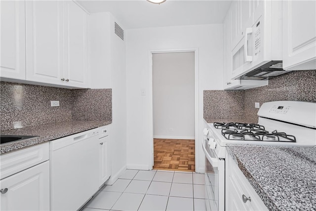 kitchen with stone counters, white cabinetry, backsplash, white appliances, and light tile patterned floors