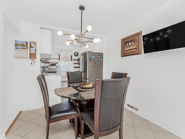 dining area with light tile patterned floors and an inviting chandelier