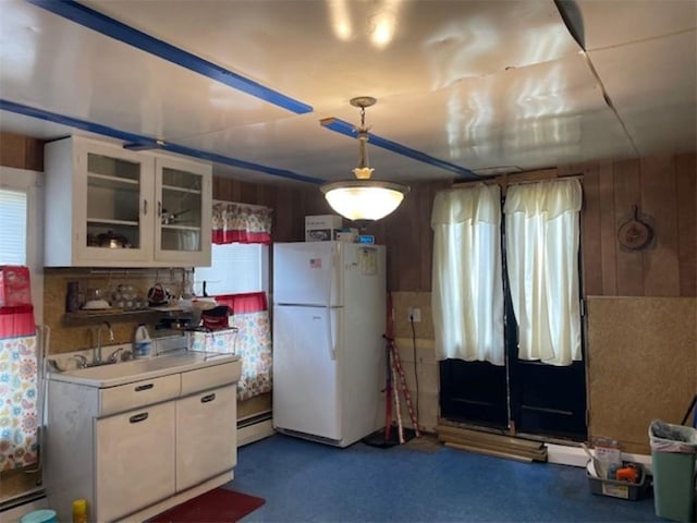 kitchen featuring a healthy amount of sunlight, white cabinetry, white fridge, and a baseboard radiator