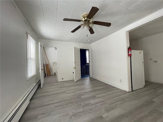 interior space with ceiling fan, a baseboard radiator, and light wood-type flooring