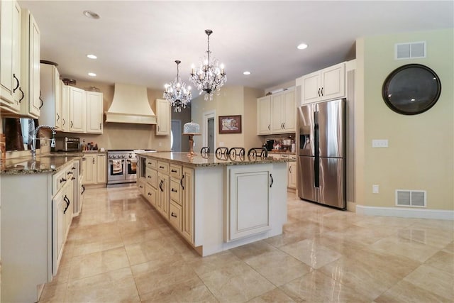 kitchen with a center island, premium range hood, dark stone counters, decorative light fixtures, and stainless steel appliances