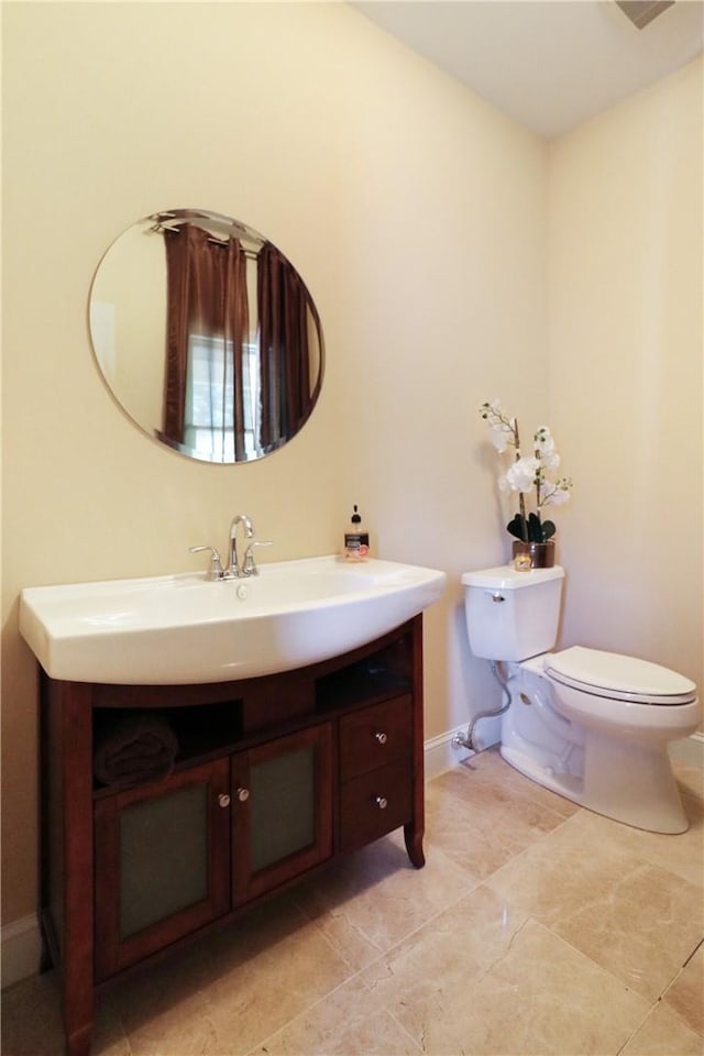 bathroom featuring tile patterned flooring, vanity, and toilet