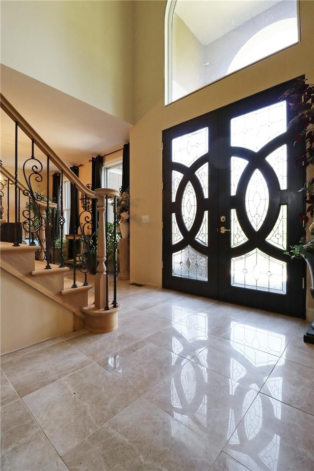 entryway with french doors and a towering ceiling