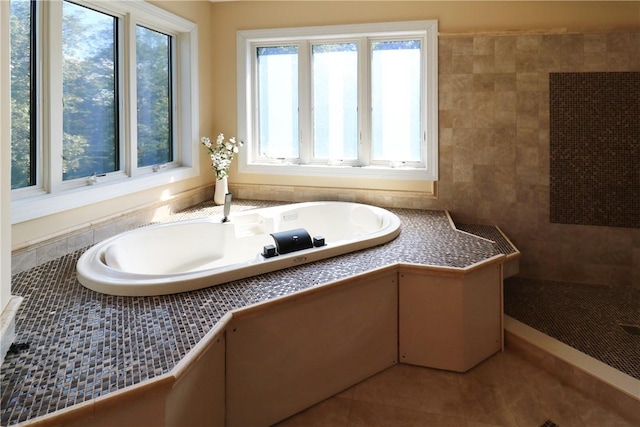 bathroom featuring tile patterned flooring and a tub to relax in