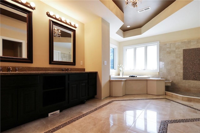 bathroom featuring tile patterned flooring, vanity, a raised ceiling, and an inviting chandelier