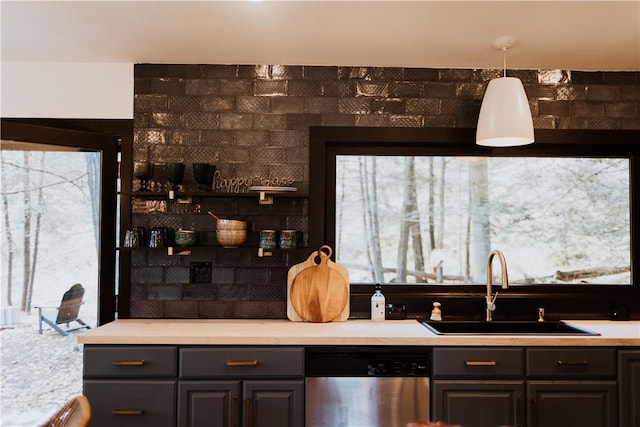 kitchen featuring hanging light fixtures, a healthy amount of sunlight, sink, and stainless steel dishwasher