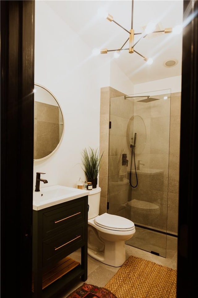 bathroom with tile patterned flooring, toilet, a tile shower, and vanity