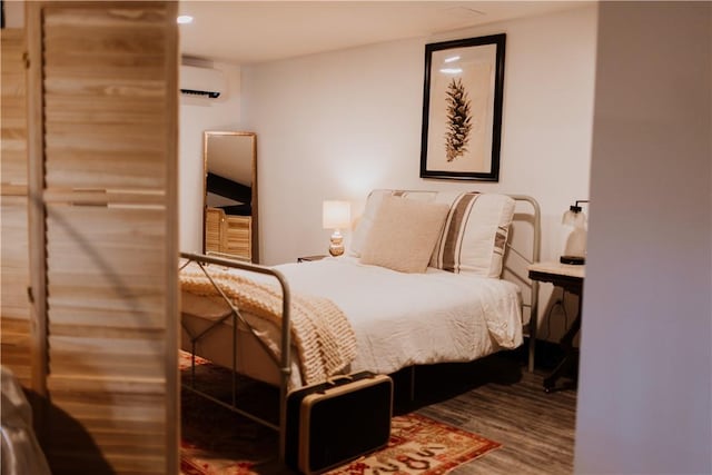 bedroom featuring wood-type flooring and a wall mounted air conditioner