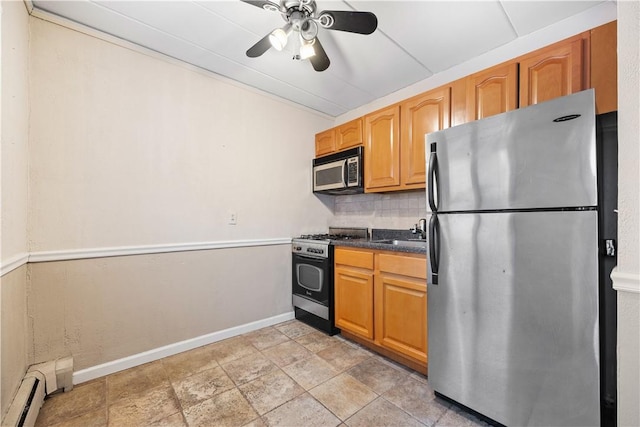 kitchen featuring sink, ceiling fan, baseboard heating, appliances with stainless steel finishes, and tasteful backsplash