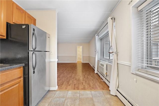 kitchen with light hardwood / wood-style floors, stainless steel refrigerator, baseboard heating, and a wall unit AC