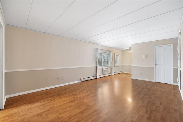 spare room featuring wood-type flooring, baseboard heating, and ceiling fan