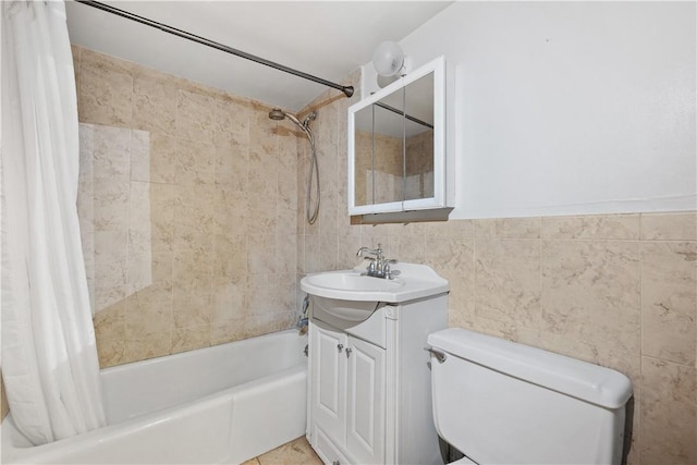 full bathroom featuring vanity, shower / bathtub combination with curtain, toilet, and tile walls