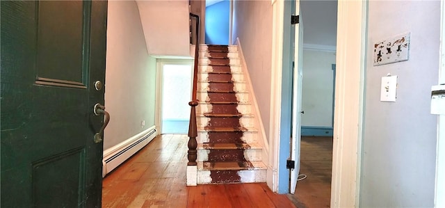 staircase with hardwood / wood-style floors and a baseboard radiator