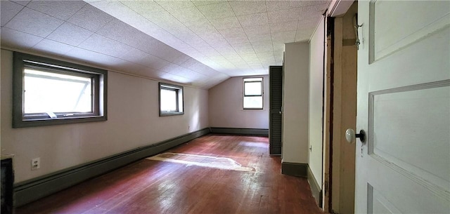 bonus room featuring a baseboard heating unit, vaulted ceiling, and dark wood-type flooring