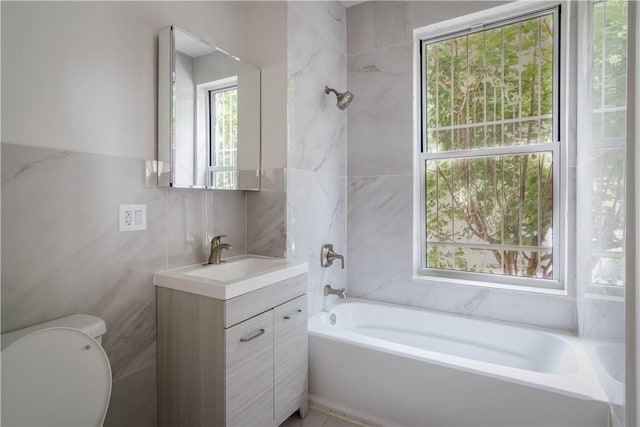 full bathroom featuring vanity, tile walls, and a wealth of natural light