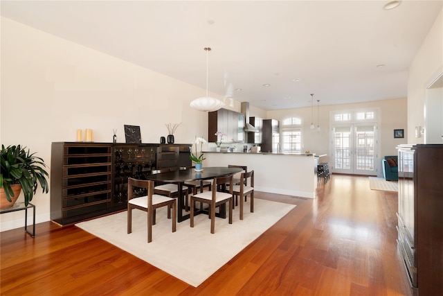 dining space featuring baseboards, wood finished floors, and french doors