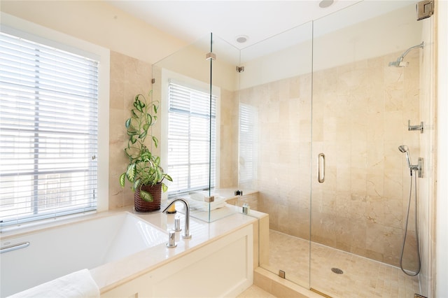 bathroom featuring a stall shower and a bath