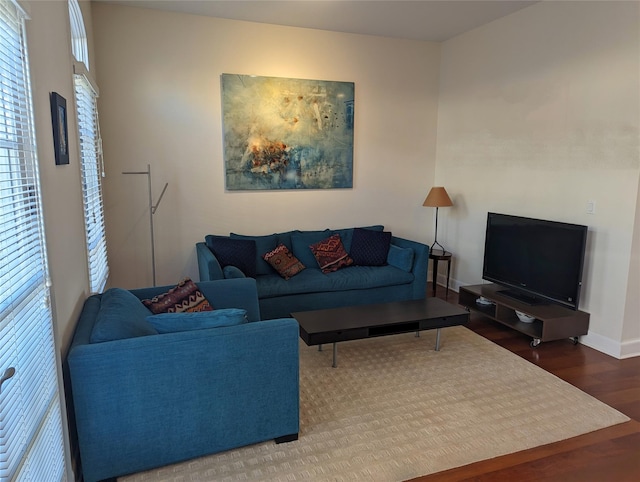 living area with baseboards and wood finished floors