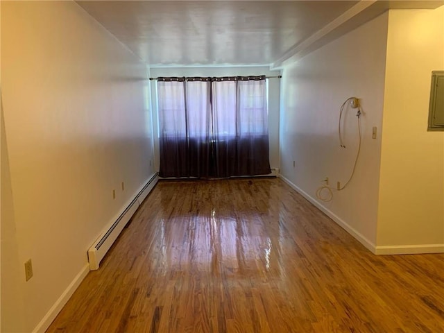 unfurnished room with wood-type flooring and a baseboard radiator