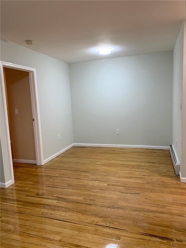 empty room with light wood-type flooring and a baseboard radiator