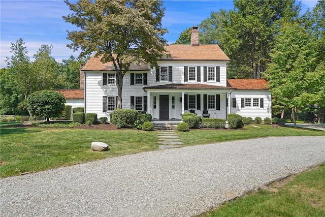 colonial-style house with covered porch and a front yard