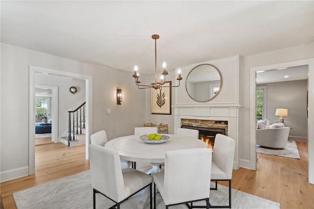 dining space with a notable chandelier and light hardwood / wood-style flooring