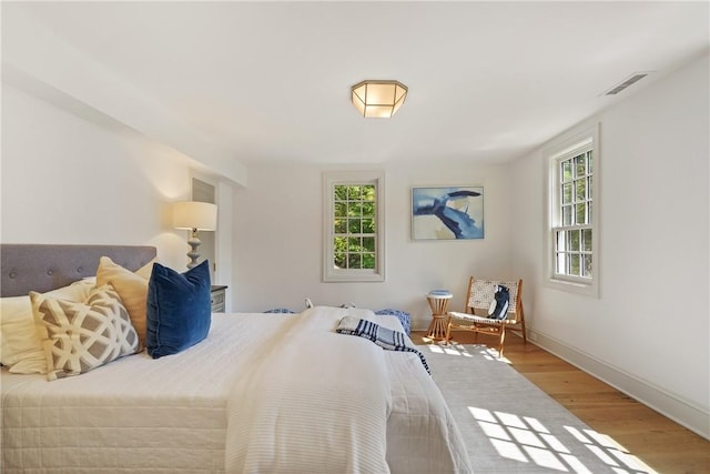 bedroom featuring multiple windows and light wood-type flooring