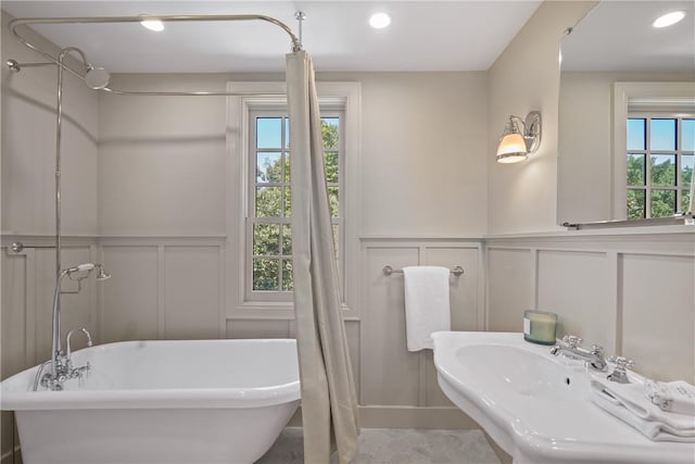 bathroom featuring plenty of natural light, shower with separate bathtub, and sink