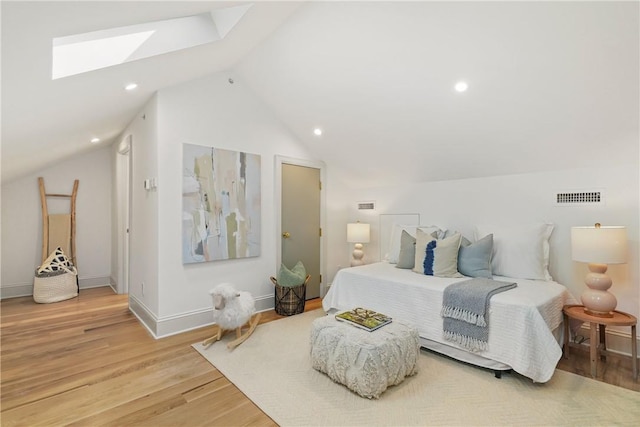 bedroom with hardwood / wood-style floors and vaulted ceiling with skylight