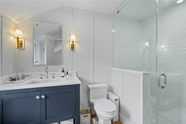 bathroom with vanity, toilet, a shower with door, and lofted ceiling