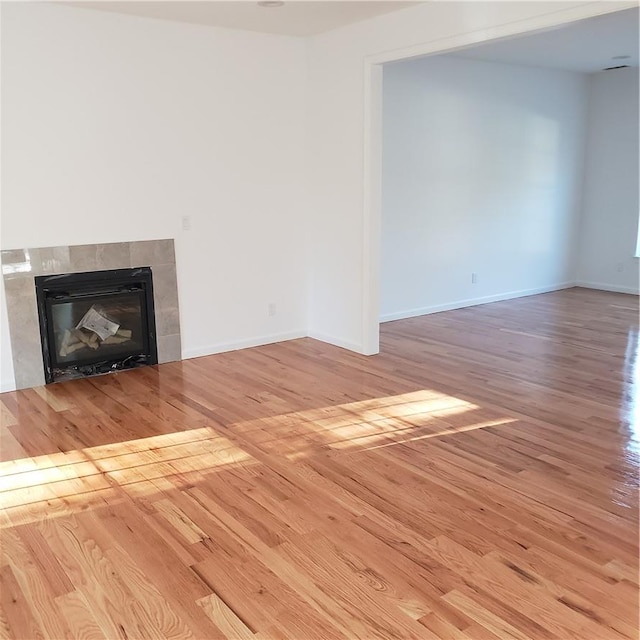 details featuring a tile fireplace, wooden walls, and hardwood / wood-style floors