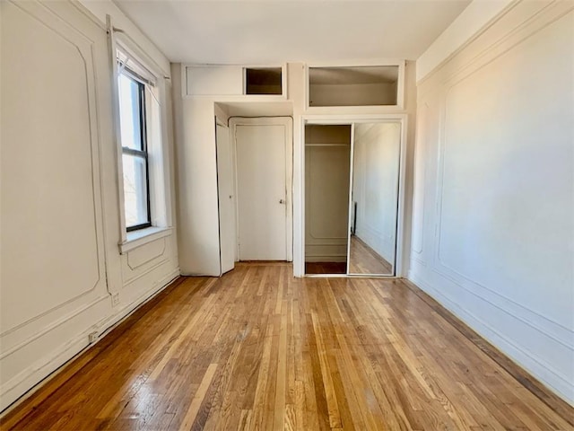 unfurnished bedroom featuring multiple closets and light hardwood / wood-style flooring