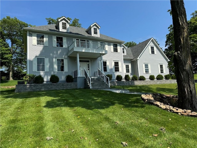 colonial home featuring a front yard and a balcony