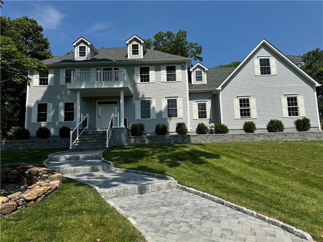 colonial house with a balcony and a front yard