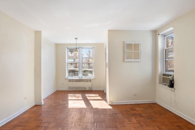 unfurnished dining area with radiator heating unit, dark parquet flooring, and plenty of natural light