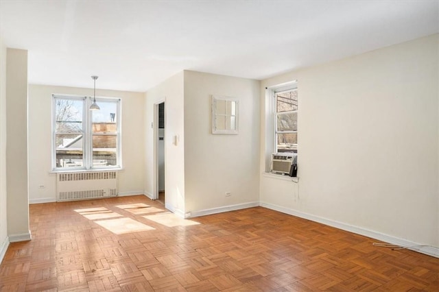 unfurnished room with light parquet flooring, radiator, and cooling unit