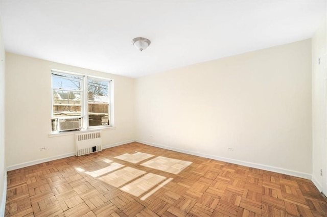 spare room with cooling unit, radiator, and light parquet floors