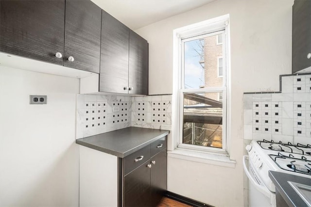 kitchen with white range with gas cooktop and tasteful backsplash