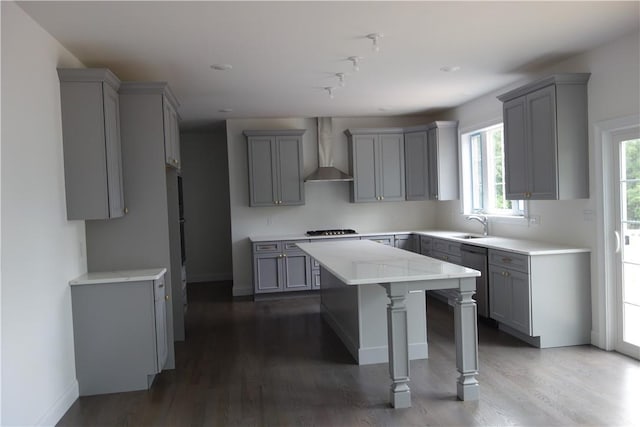 kitchen featuring gray cabinetry, a kitchen island, and wall chimney range hood